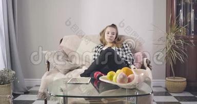 少女白种人坐在沙发上<strong>看</strong>电视的肖像。 在家<strong>看电影</strong>或系列剧的漂亮小姐